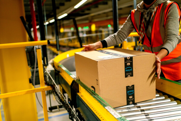 A worker collections an Amazon package in preparation for Prime Day